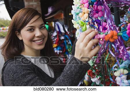 Stock Image - Mixed race woman looking at souvenir shop. Fotosearch