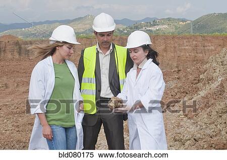 Stock Photography - Workers analyzing rock specimen. Fotosearch