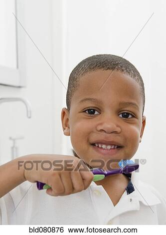 Stock Photograph - African American boy brushing teeth. Fotosearch