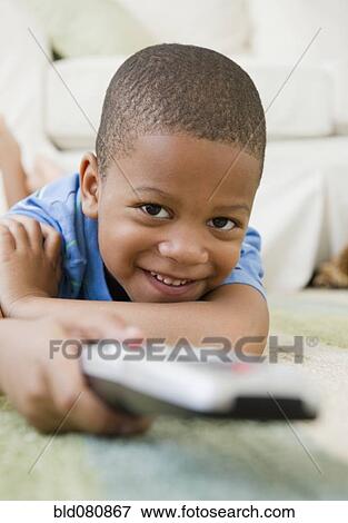 African American boy laying on floor watching television View Large Photo Image Stock Photo - African American boy laying on floor watching television. Fotosearch