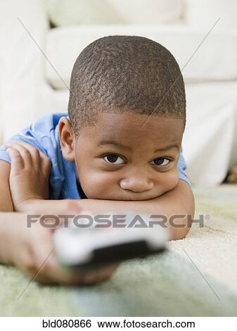 African American boy laying on floor watching television View Large Photo Image Stock Photograph - African American boy laying on floor watching television. Fotosearch