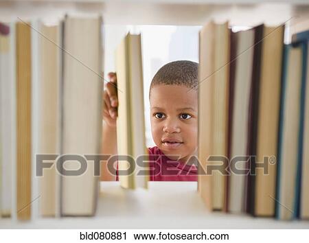 Stock Image - African American boy selecting book. Fotosearch