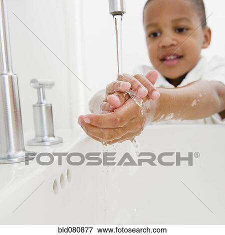 Stock Photo - African American boy washing hands. Fotosearch