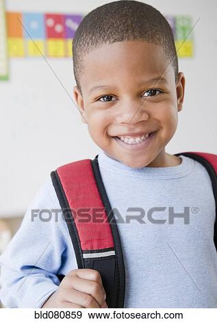 Stock Photo - African American boy wearing backpack in school. Fotosearch
