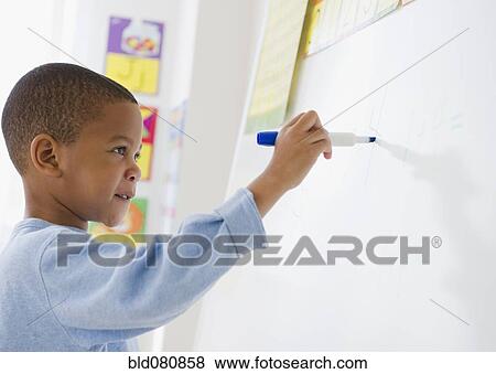 Stock Photo - African American boy writing on white board. Fotosearch