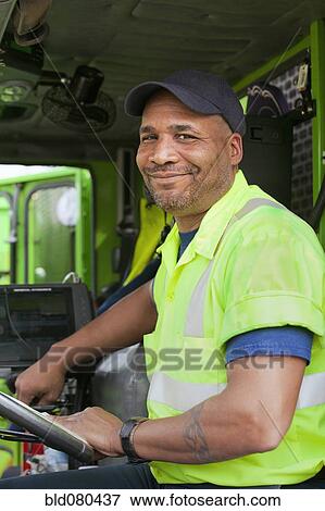 Stock Photo - African American man driving garbage truck. Fotosearch