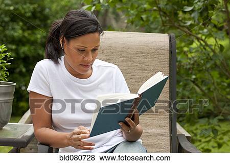African American woman reading book in back yard View Large Photo Image Stock Photo - African American woman reading book in back yard. Fotosearch