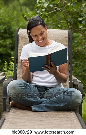 African American woman reading book in back yard View Large Photo Image Stock Photo - African American woman reading book in back yard. Fotosearch