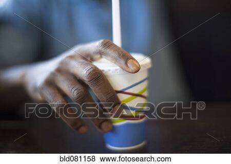 Stock Photo - Black man holding soda cup. Fotosearch