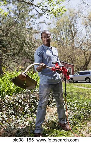 Black man holding weed trimmer View Large Photo Image Stock Photography - Black man holding weed trimmer. Fotosearch