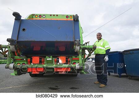 Stock Photo - Black man operating garbage truck. Fotosearch