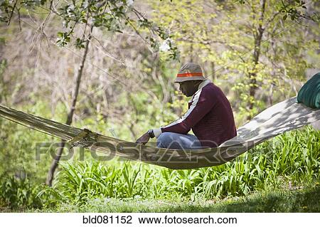 Black man sitting in hammock View Large Photo Image Stock Image - Black man sitting in hammock. Fotosearch
