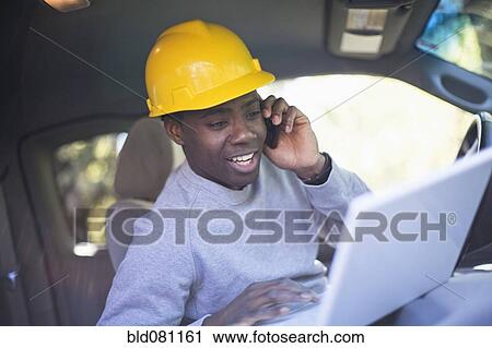 Black man wearing hard hat in vehicle using laptop View Large Photo Image Stock Image - Black man wearing hard hat in vehicle using laptop. Fotosearch