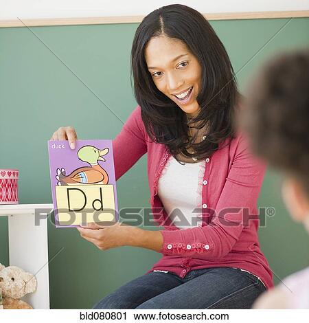 Stock Image - Black teacher showing letter d flash card to student. Fotosearch