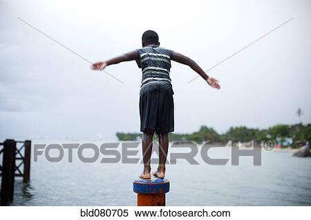 Boy on pipe about to jump in the water View Large Photo Image Stock Photography - Boy on pipe about to jump in the water. Fotosearch