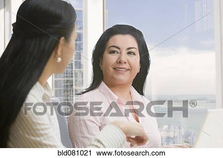 Stock Image - Businesswomen meeting in office. Fotosearch