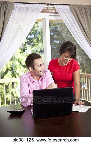 Couple paying bills and using laptop View Large Photo Image Stock Photography - Couple paying bills and using laptop. Fotosearch
