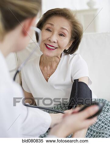 Doctor checking blood pressure of patient View Large Photo Image Stock Photography - Doctor checking blood pressure of patient. Fotosearch