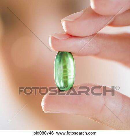Hand holding green capsule View Large Photo Image Stock Photograph - Hand holding green capsule. Fotosearch