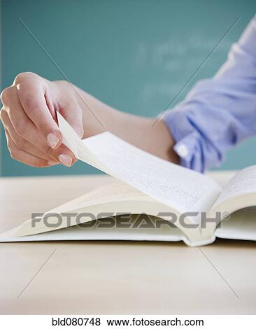 Stock Photo - Hand turning page in book. Fotosearch