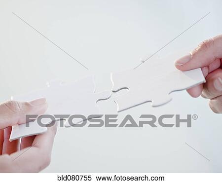 Hands connecting jigsaw puzzle pieces View Large Photo Image Stock Photography - Hands connecting jigsaw puzzle pieces. Fotosearch