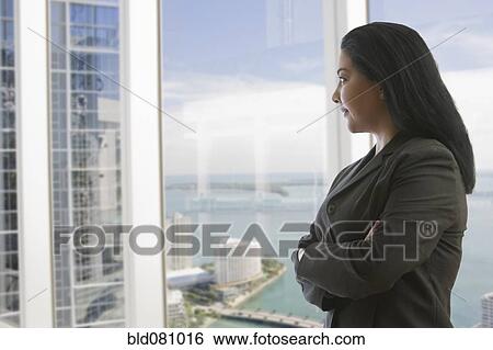 Hispanic businesswoman with arms crossed near window View Large Photo Image Stock Photograph - Hispanic businesswoman with arms crossed near window. Fotosearch