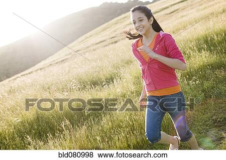Stock Photo - Hispanic girl running in field. Fotosearch