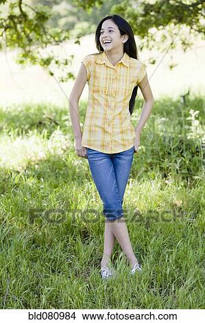 Picture - Hispanic girl standing in field. Fotosearch