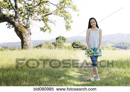 Stock Photography - Hispanic girl standing in field. Fotosearch