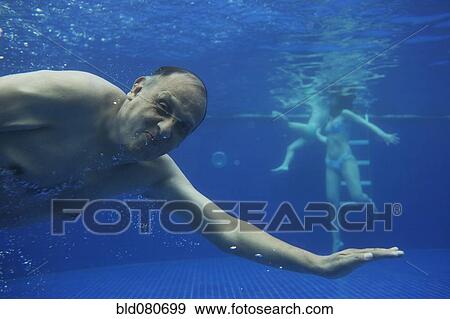Stock Photo - Hispanic man swimming underwater. Fotosearch