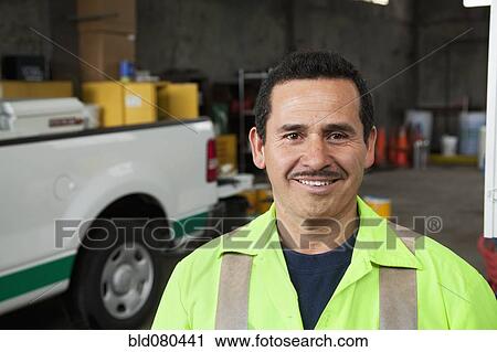 Hispanic sanitation worker smiling in garage View Large Photo Image Stock Image - Hispanic sanitation worker smiling in garage. Fotosearch
