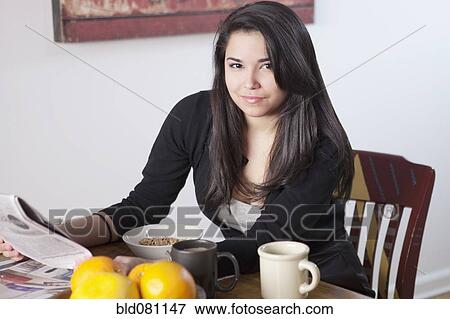 Hispanic woman eating breakfast and reading newspaper View Large Photo Image Stock Photo - Hispanic woman eating breakfast and reading newspaper. Fotosearch