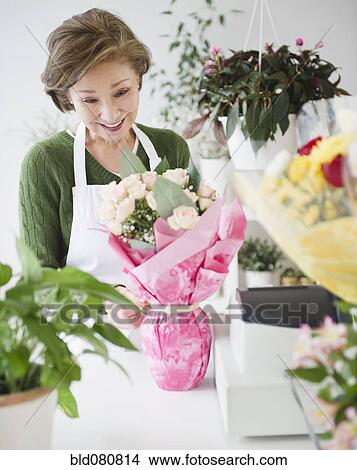 Picture - Japanese florist wrapping flower bouquet. Fotosearch