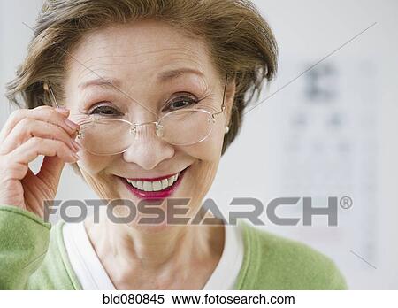 Stock Photography - Japanese woman holding eyeglasses. Fotosearch