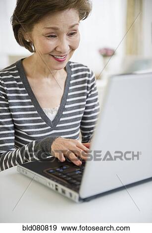 Stock Photo - Japanese woman using laptop. Fotosearch