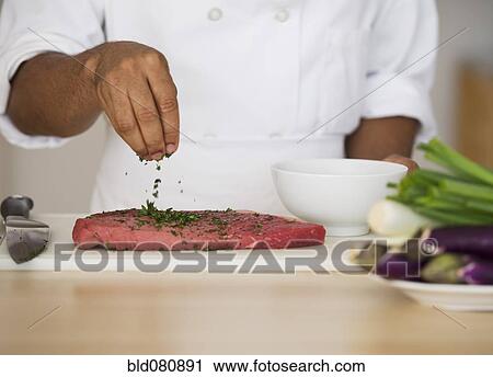 Mixed race chef seasoning steak View Large Photo Image Stock Image - Mixed race chef seasoning steak. Fotosearch