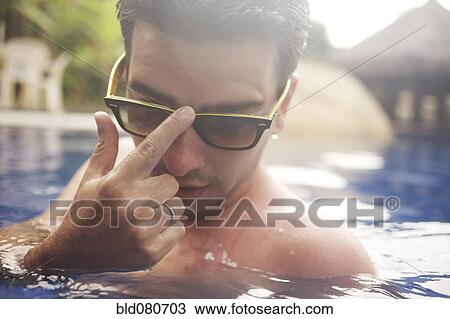 Mixed race man adjusting sunglasses in swimming pool View Large Photo Image Stock Image - Mixed race man adjusting sunglasses in swimming pool. Fotosearch