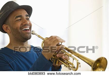 Stock Image - Mixed race man playing trumpet. Fotosearch