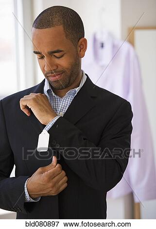 Mixed race shopper making face at price tag on jacket View Large Photo Image Stock Photo - Mixed race shopper making face at price tag on jacket. Fotosearch
