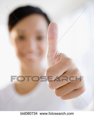 Mixed race woman giving thumbs up sign View Large Photo Image Picture - Mixed race woman giving thumbs up sign. Fotosearch