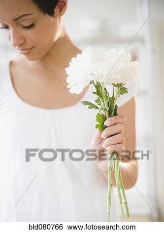 Mixed race woman holding flowers View Large Photo Image Stock Photograph - Mixed race woman holding flowers. Fotosearch