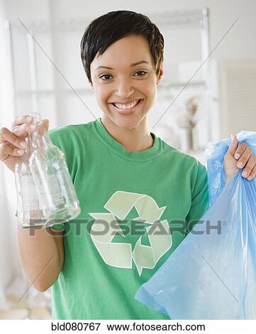 Mixed race woman recycling bottles View Large Photo Image Stock Photo - Mixed race woman recycling bottles. Fotosearch