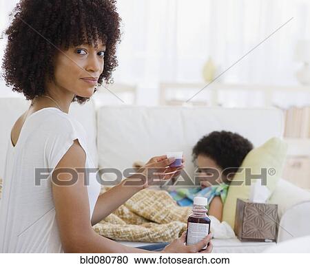 Mother giving cough syrup to sick daughter View Large Photo Image Stock Image - Mother giving cough syrup to sick daughter. Fotosearch