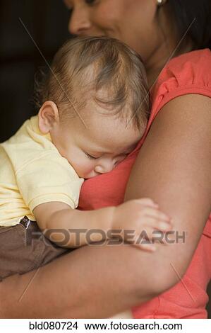 Picture - Mother holding sleeping child. Fotosearch