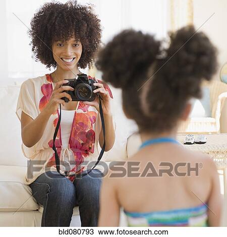 Stock Image - Mother photographing daughter. Fotosearch