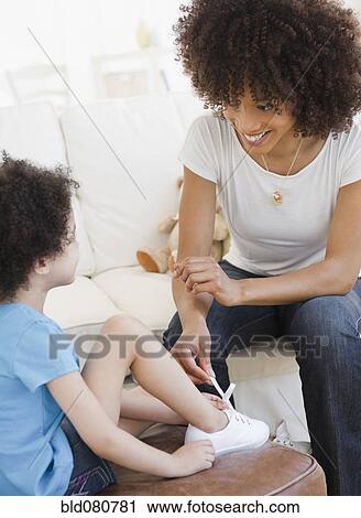 Mother tying shoe of daughter View Large Photo Image Stock Image - Mother tying shoe of daughter. Fotosearch