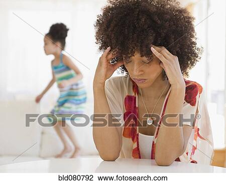 Mother with headache and daughter jumping on sofa View Large Photo Image Stock Image - Mother with headache and daughter jumping on sofa. Fotosearch