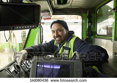 Stock Photograph - Pacific Islander man driving garbage truck. Fotosearch
