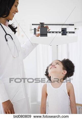 Stock Photo - Pediatrician weighing patient. Fotosearch