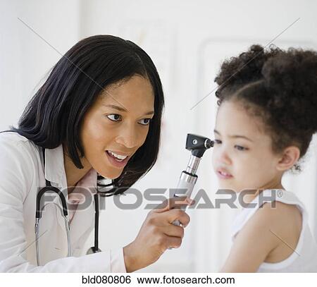 Stock Photograph - Pediatrician with otoscope examining patient. Fotosearch